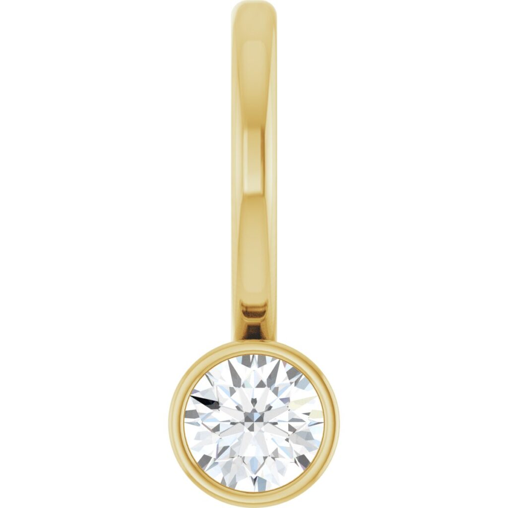 Small round diamond in a yellow gold bezel hanging from a slim attached yellow gold bail
