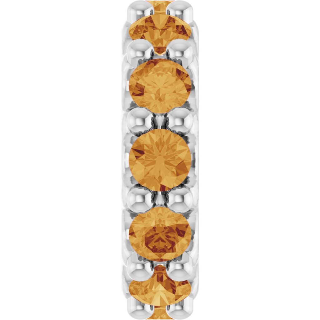 Close view of a charm set with a vertical row of round orange-gold gemstones in white metal prong settings
